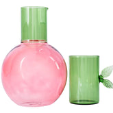 Ban.do cherry-shaped glass carafe with green stem on bedside table for easy night hydration.
