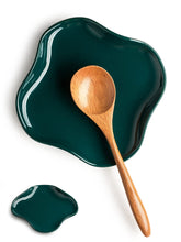 Cormomu spoon holder with ruffled edge keeps utensils organized during cooking.