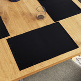 Encasa XO dining placemats in solid black provide refined table protection.