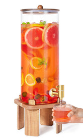 FavorFlavor 2-gallon glass dispenser on a sturdy wood stand, ready for parties.