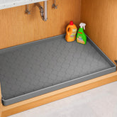 Jin&Bao under-sink mat with raised edge protects cabinets from leaks.