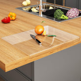 JJL acrylic cutting board with counter lip enables stable slicing on a clear surface.