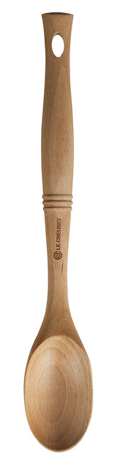 Le Creuset Revolution solid spoon with beech wood handle for durable, comfortable stirring.