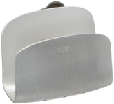 OXO suction sponge holder mounted on sink wall for secure storage.