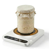 Pakusane Sourdough Warmer Mat on the counter keeps starter in the active range.