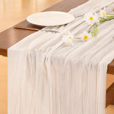Socomi ivory cheesecloth table runner draped on a long dining table for soft rustic charm