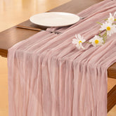Socomi pink cheesecloth table runner on a wedding arch for rustic elegance