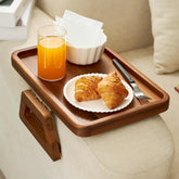 Tinamo acacia arm table clipped to a couch arm for easy snacks.