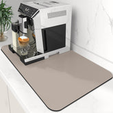 WISELIFE coffee mat in khaki absorbs spills beneath a busy coffee maker for clean counters.