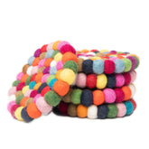 Woolygon round felt ball coaster in multicolor, closeup of its absorbent merino wool surface.
