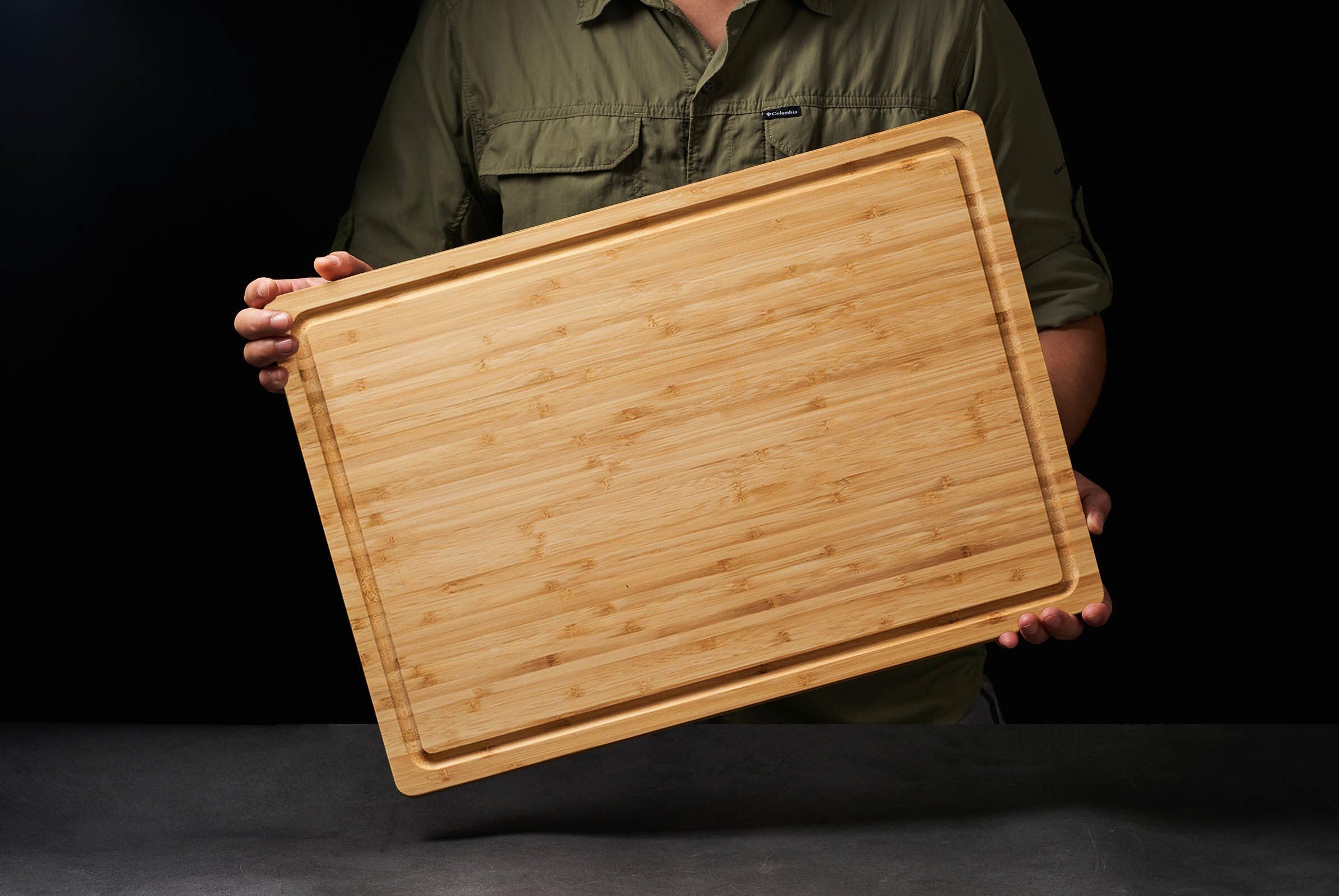 Allsum bamboo cutting board with side handles for easy transport.