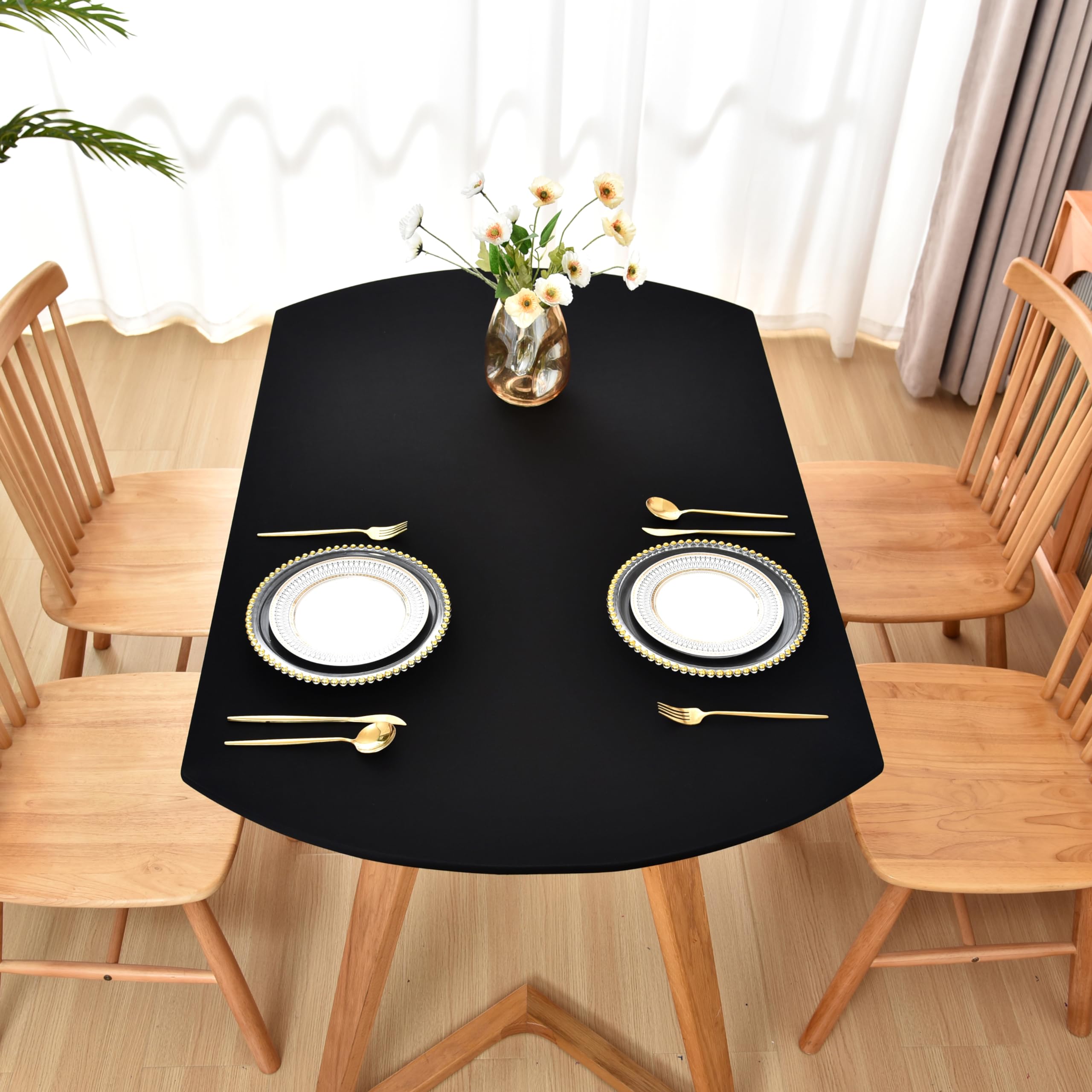 Amonsa dining setup on an oval table highlights elegant black styling.