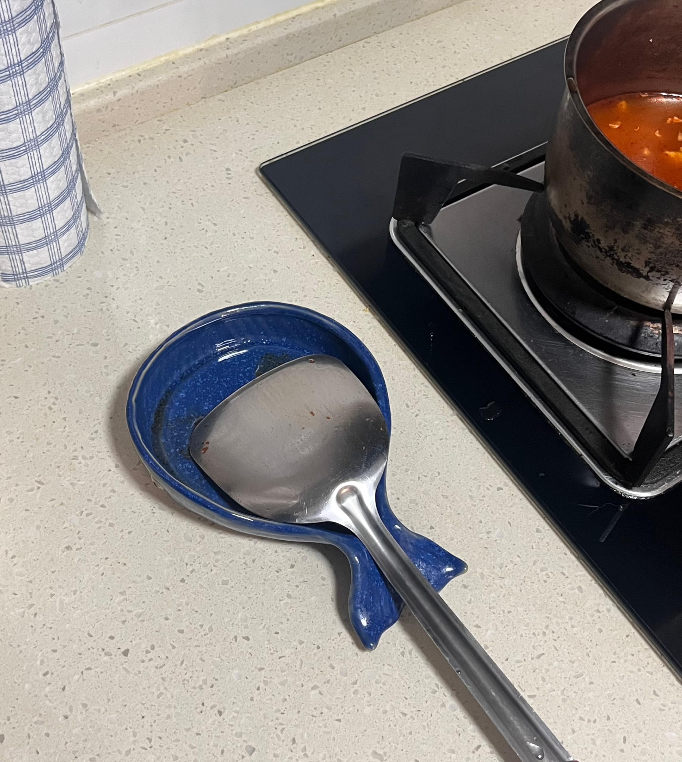 ANLYAWX heat-resistant spoon holder positioned near pots on a stove for easy access.