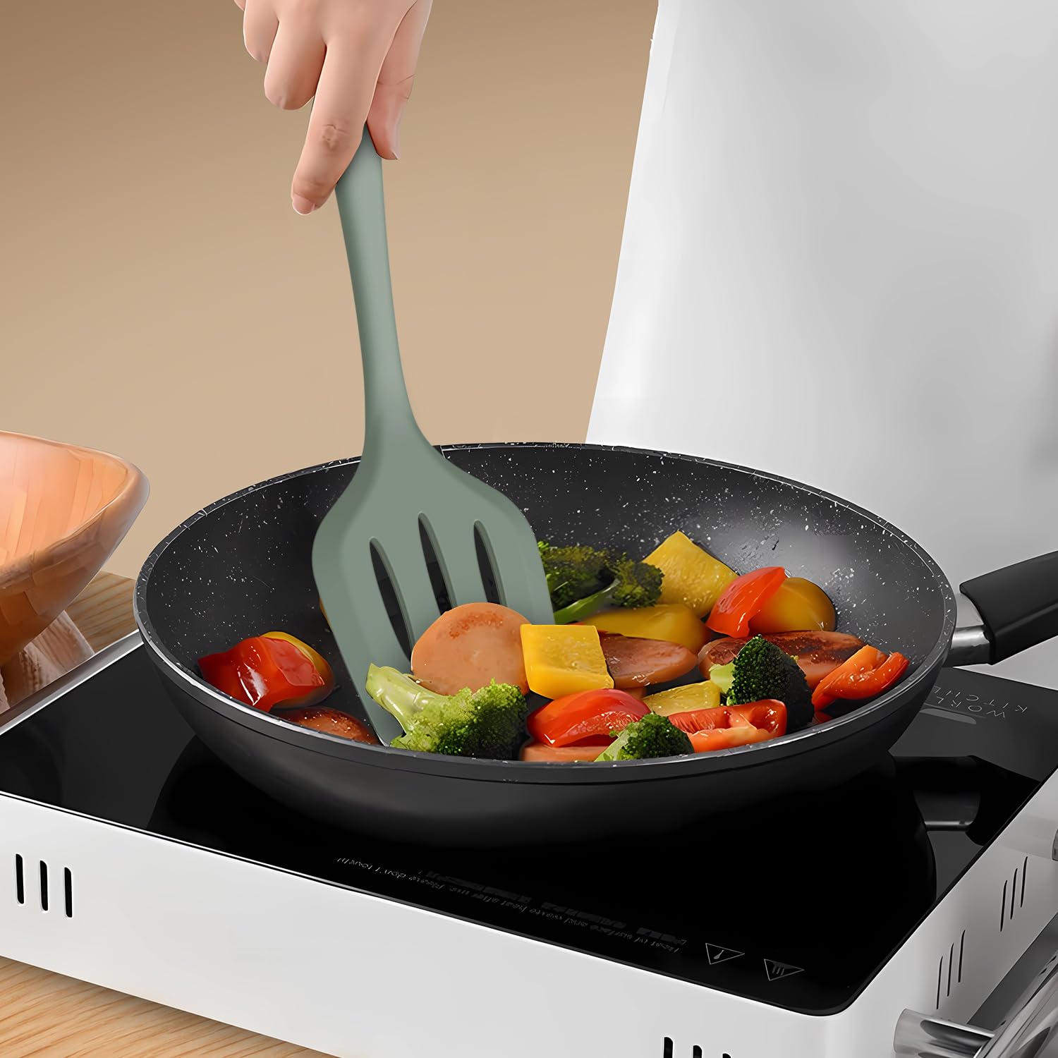 AOTHOD silicone turner flipping vegetables, gentle on nonstick surfaces.