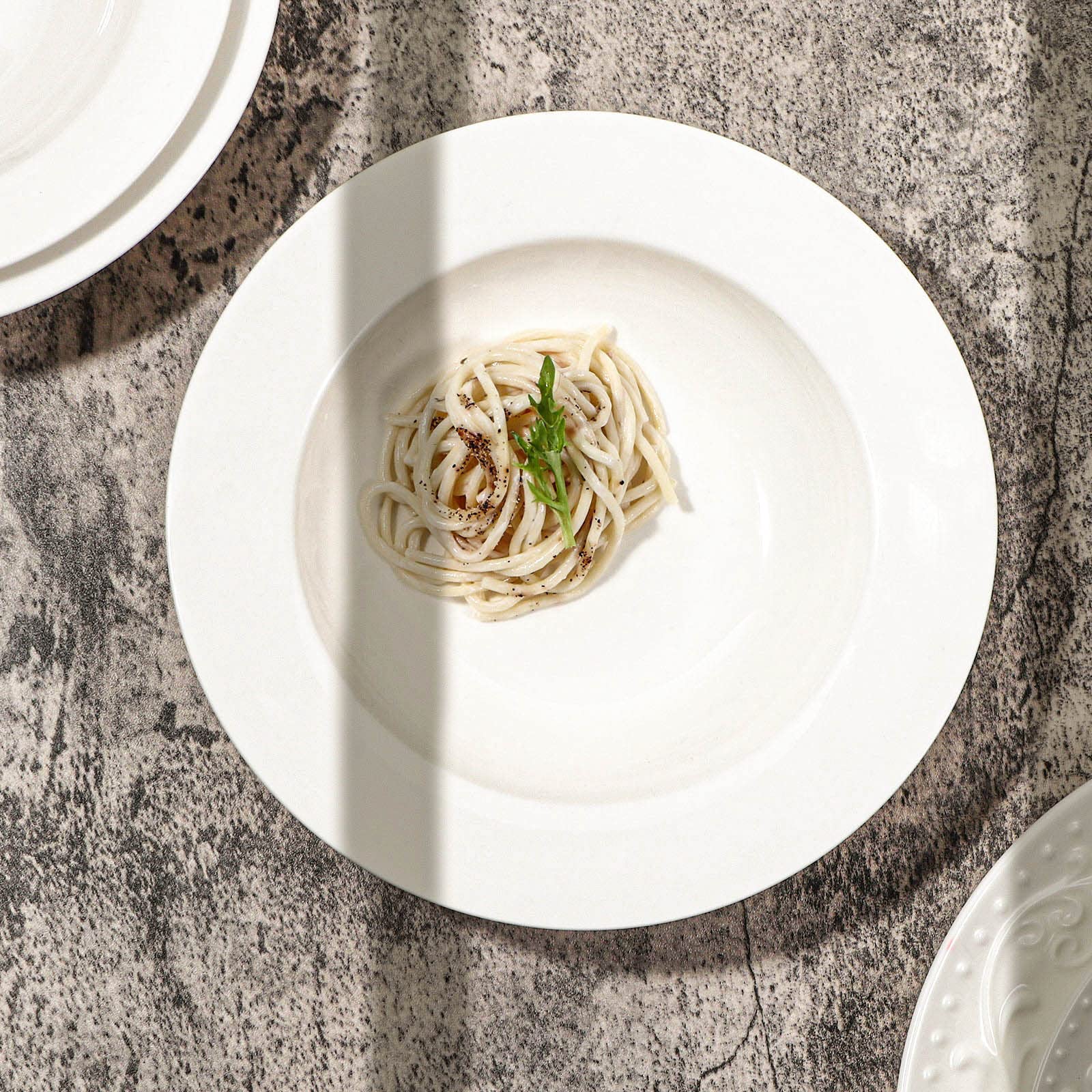 Artena stackable white dishes neatly organized for storage.
