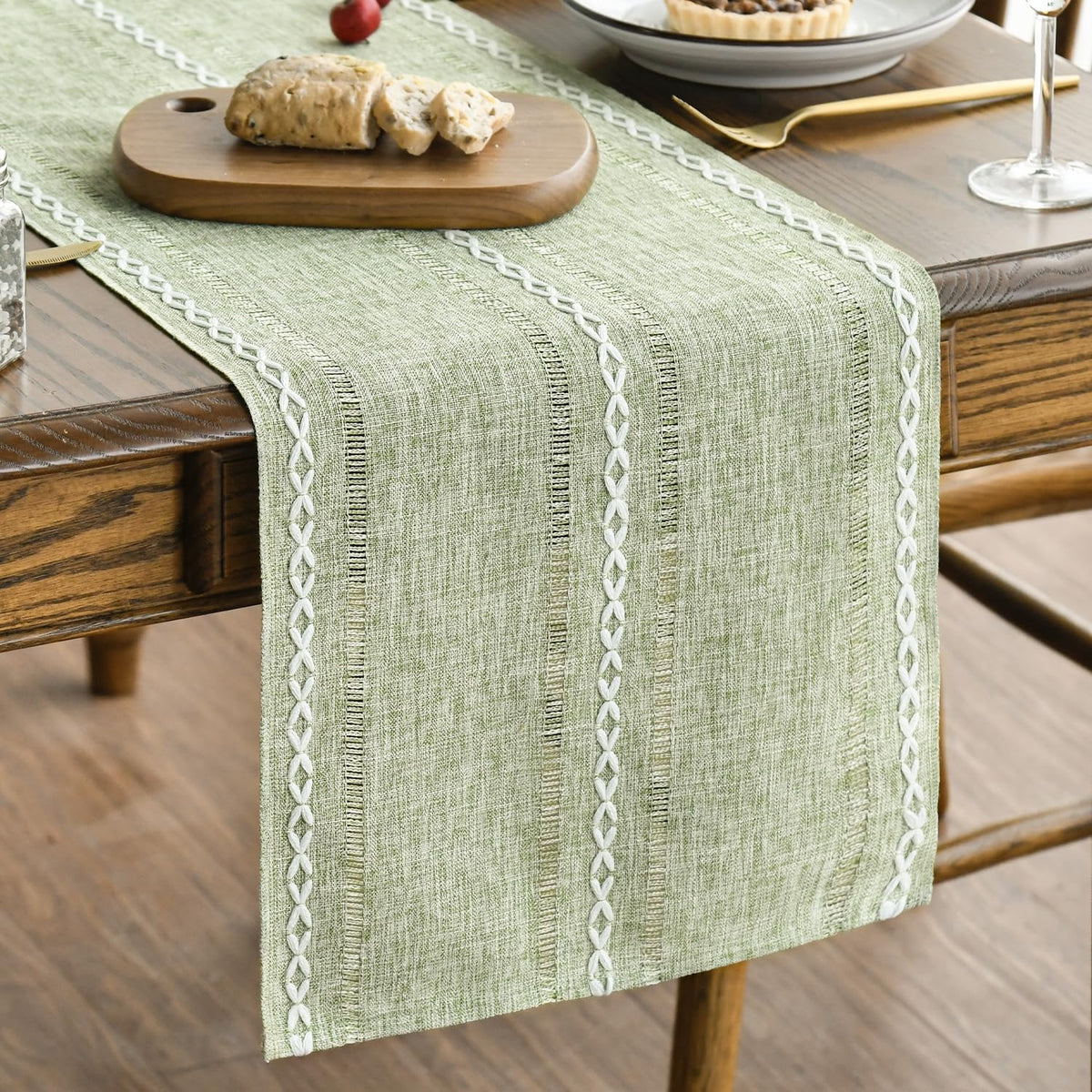 Artoid Mode sage green runner closeup of embroidered stripes for festive tables.