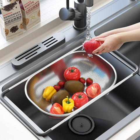 Balavina colander rinsing vegetables under running water.