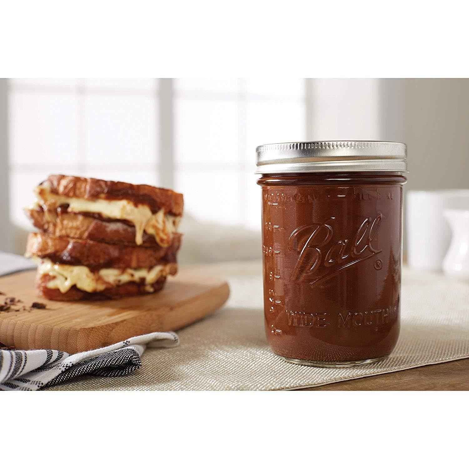 Ball mason jar with lids in closeup, showing sealing band and glass clarity.