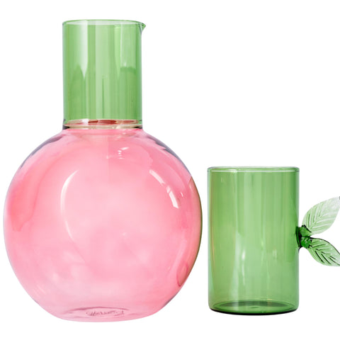Ban.do cherry-shaped glass carafe with green stem on bedside table for easy night hydration.