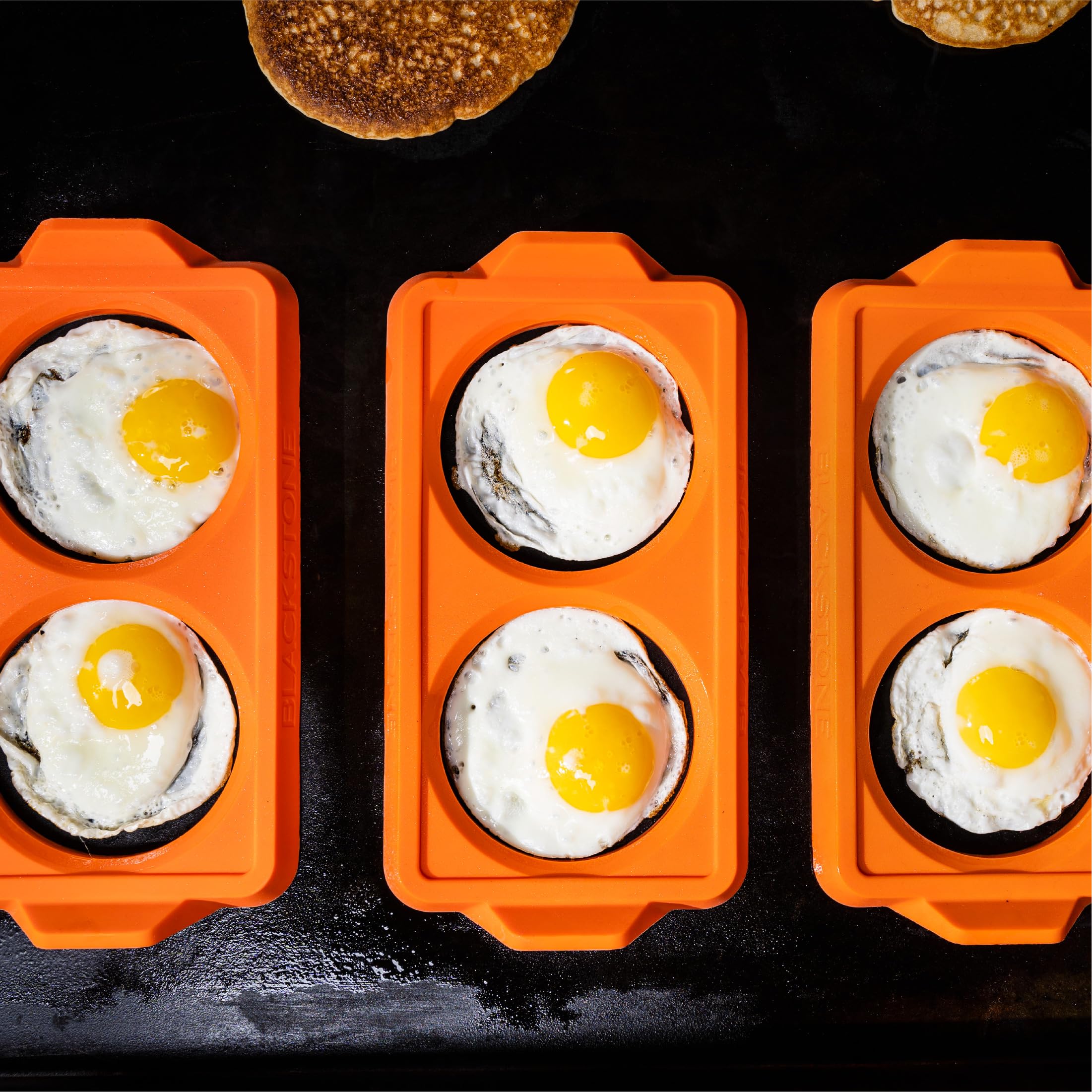 Blackstone silicone egg rings in action on a griddle for perfectly round eggs.