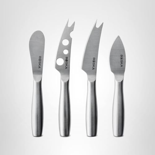 Hard cheese being cut with Boska knives on board