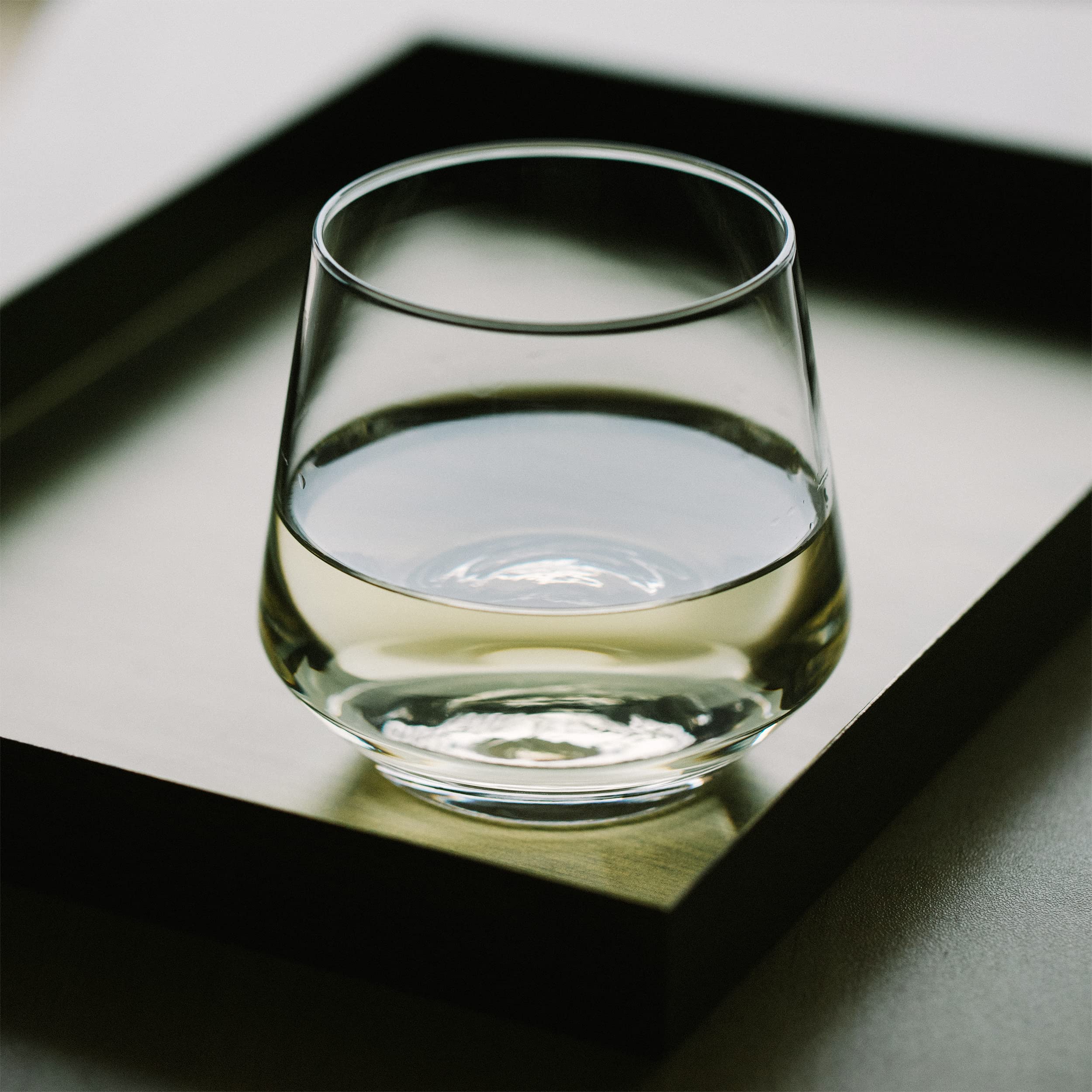 BTaT stemless wine glass 12 oz on table ready for a toast.