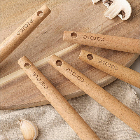 CAROTE tongs with wood handle ready for flipping and turning hot foods.