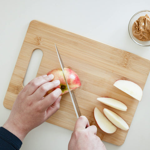 Knife-on-board use demonstrates blade-friendly surface and precision chopping.