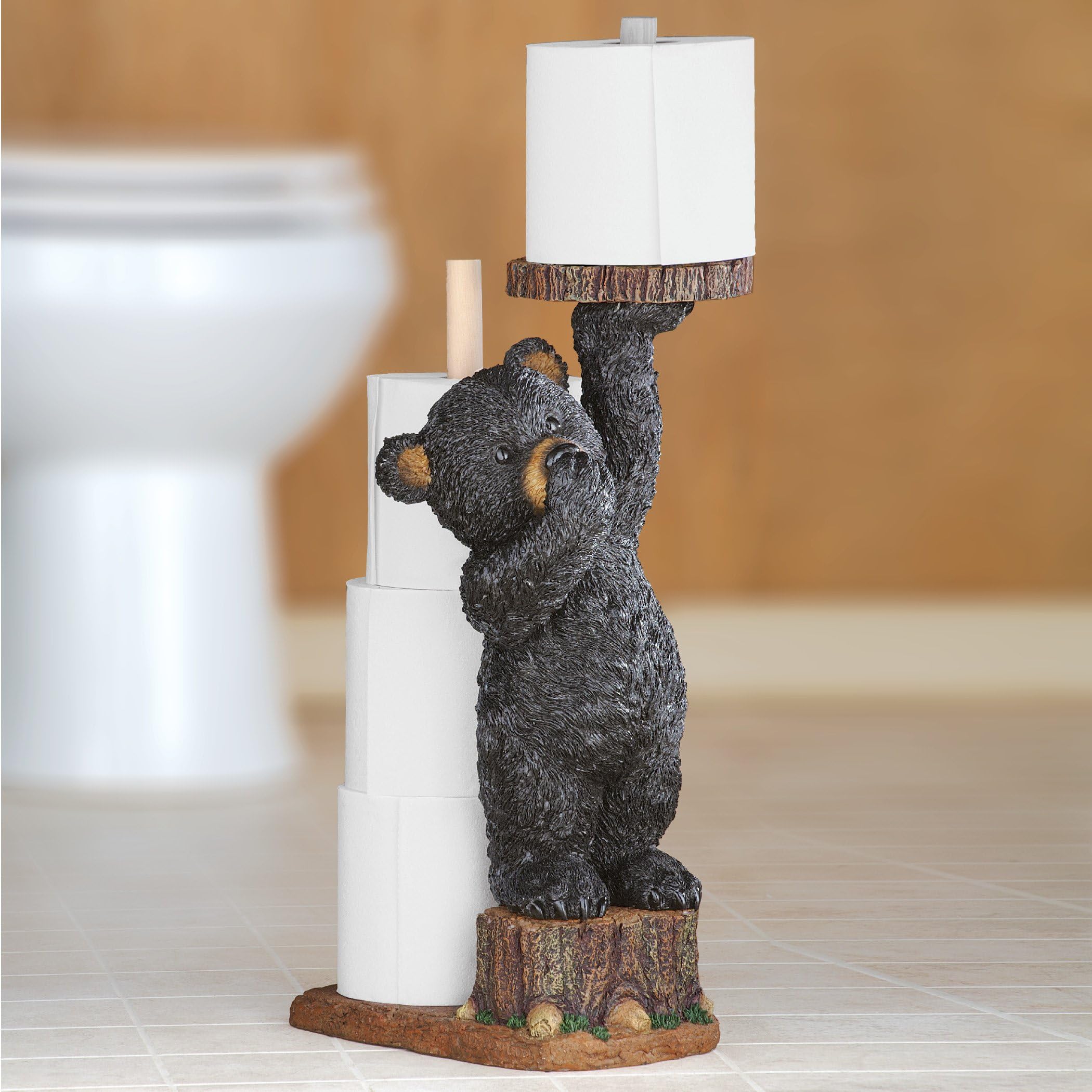 Collections Etc Aurrra Northwoods bear cub toilet paper holder, side view beside the tree stump