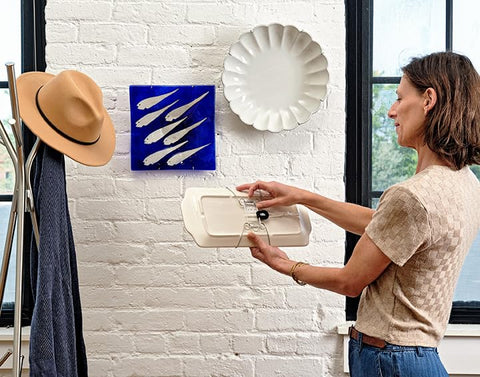Display Buddie stainless wire-arm holders suspend plates with surface protection.
