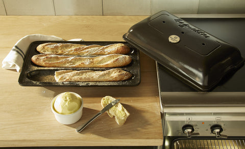 Emile Henry Baguette Baker Charcoal with lid in use demonstrates humidity control for authentic baguettes.
