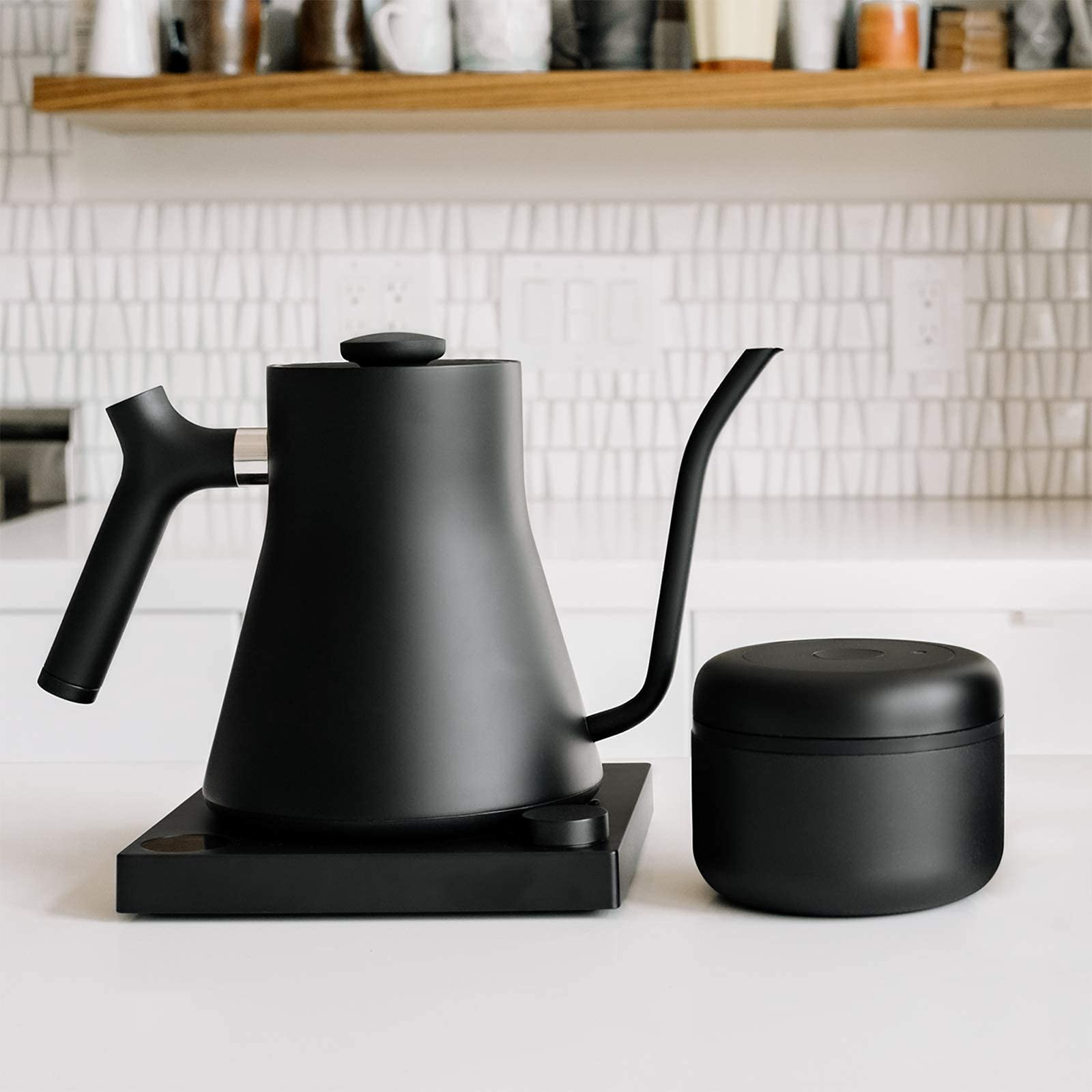 Fellow Atmos matte black canister on a kitchen counter.