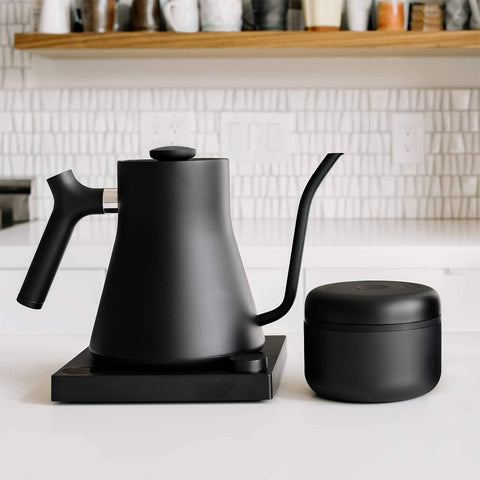 Fellow Atmos matte black canister on a kitchen counter.
