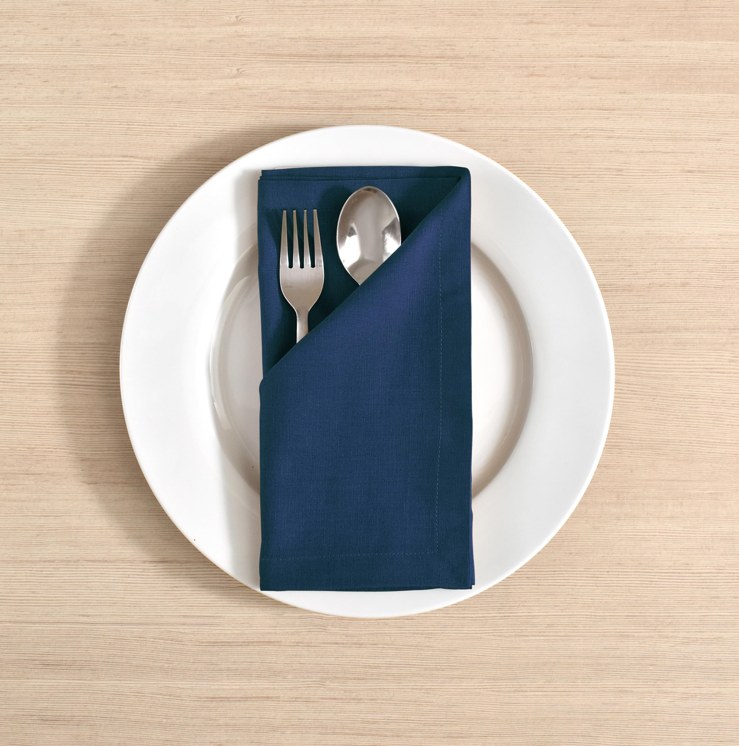 FINGERCRAFT navy napkins folded with mitered corners for a refined table.