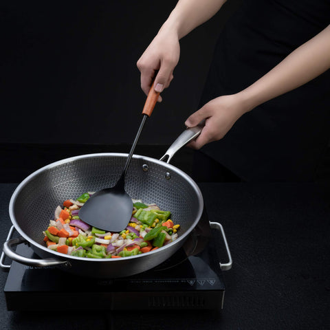 FJNATINH ladle with wooden grip suitable for scooping sauces and broth.
