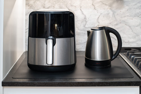 Gasare silicone mats shown under an appliance to absorb heat and protect countertops.