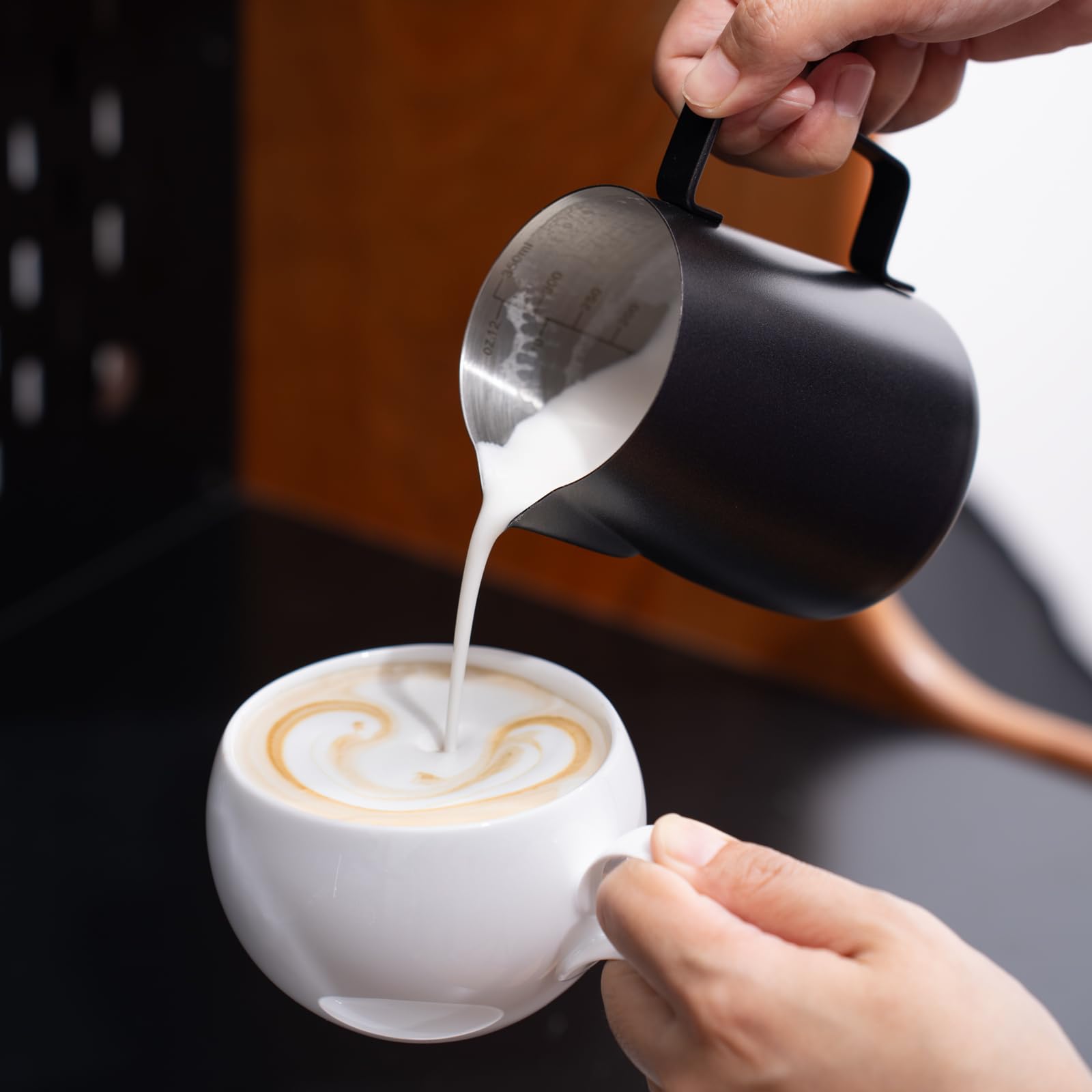 Generic matte black finish milk pitcher highlights precise pouring flow.