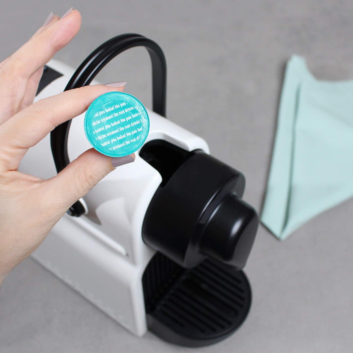 Gourmesso cleaning pods near cup illustrating rinse before serving.