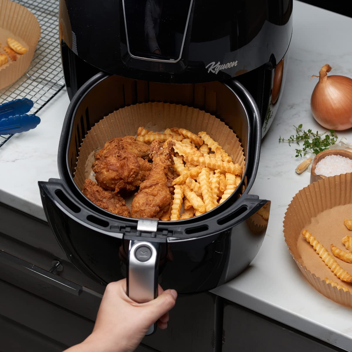 GUSTO round liners placed inside an air fryer basket showing non stick surface