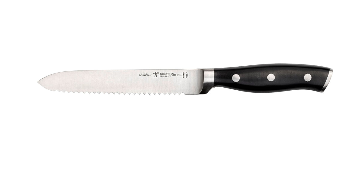 HENCKELS Forged Accent blade close-up highlighting razor-sharp serration for precise cuts.
