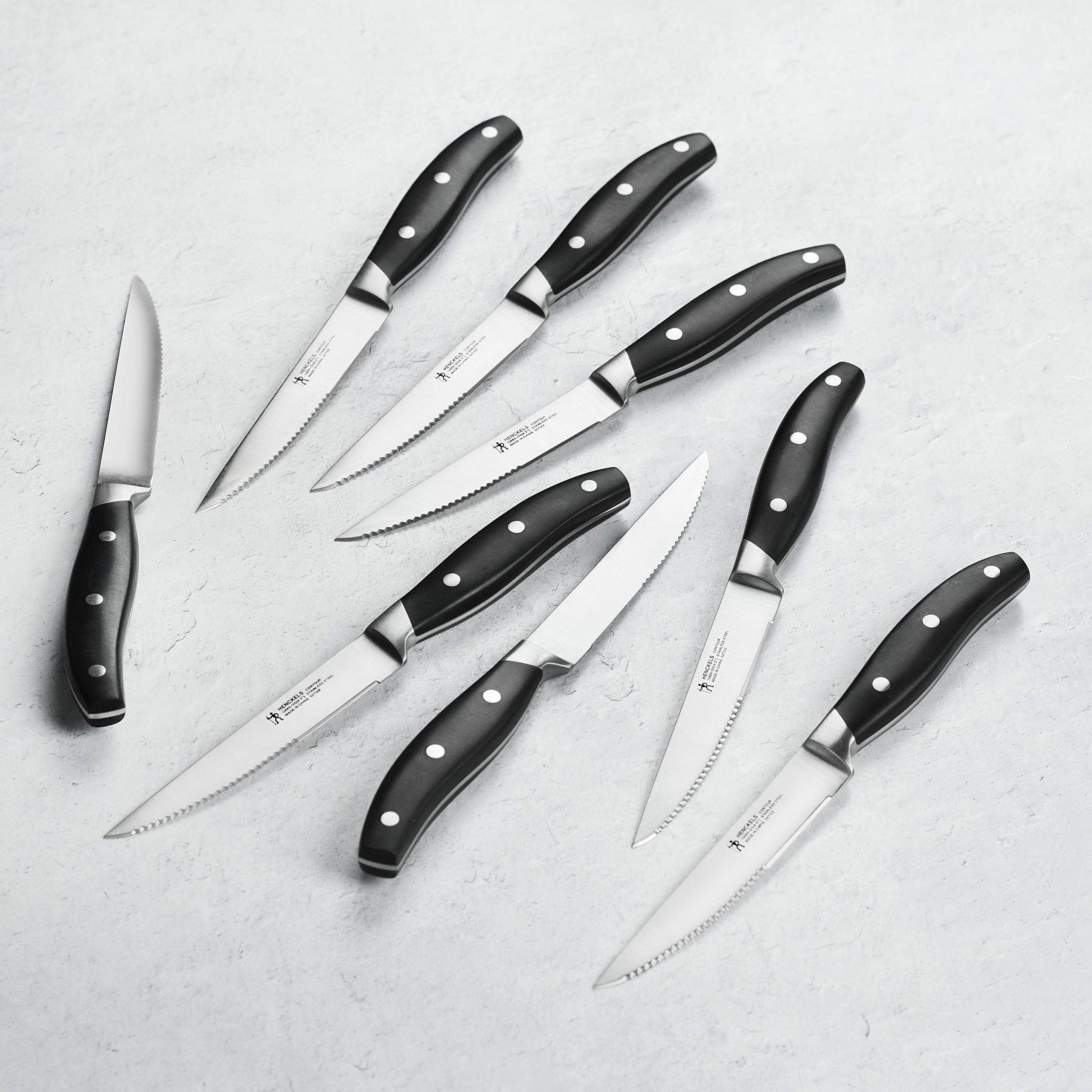 Close-up of satin-finish blades from the Henckels Forged Contour 8pc set for precise slicing.