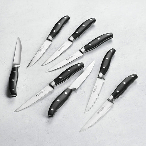 Close-up of satin-finish blades from the Henckels Forged Contour 8pc set for precise slicing.