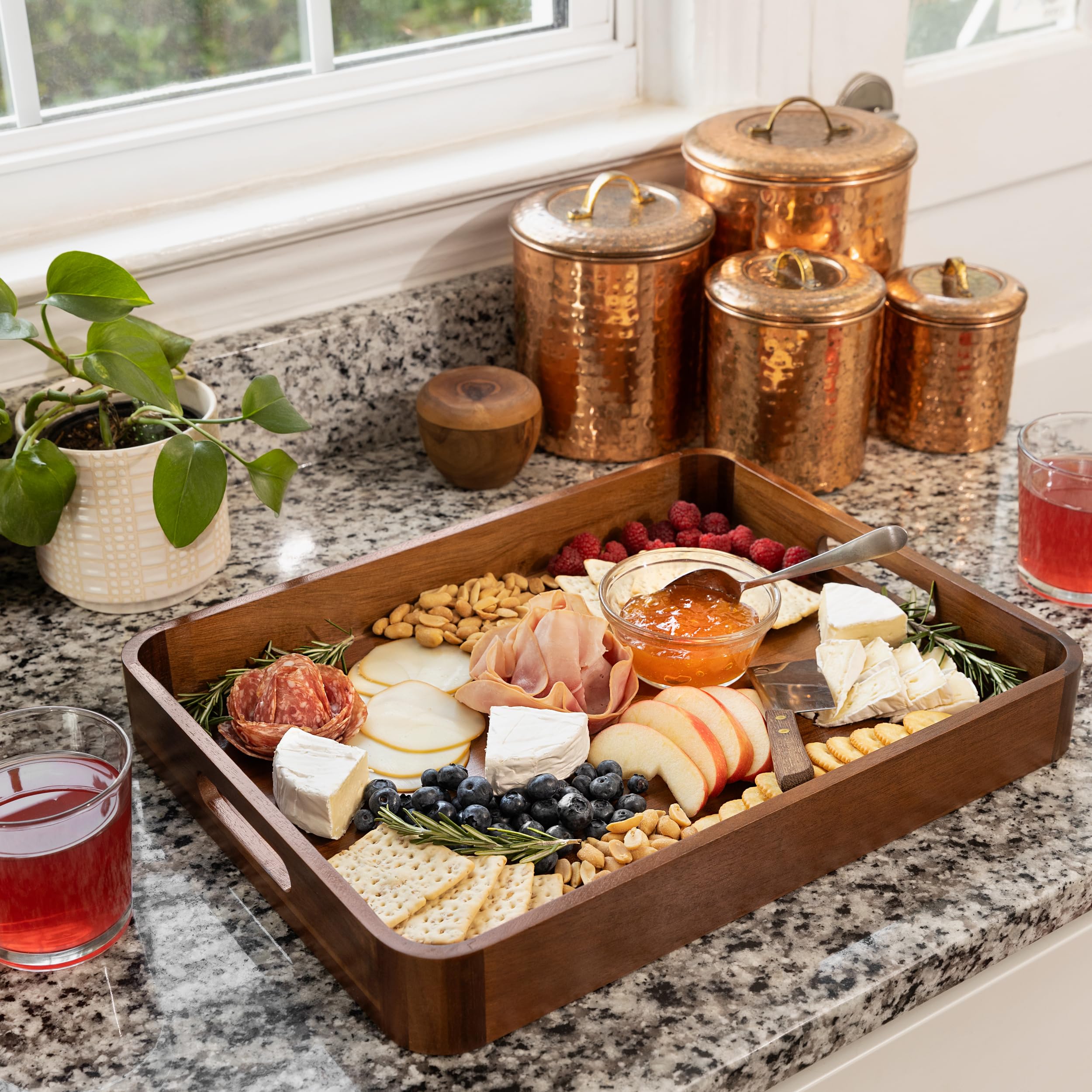 Home Beets Acacia serving tray on dining table with fruit and decor.