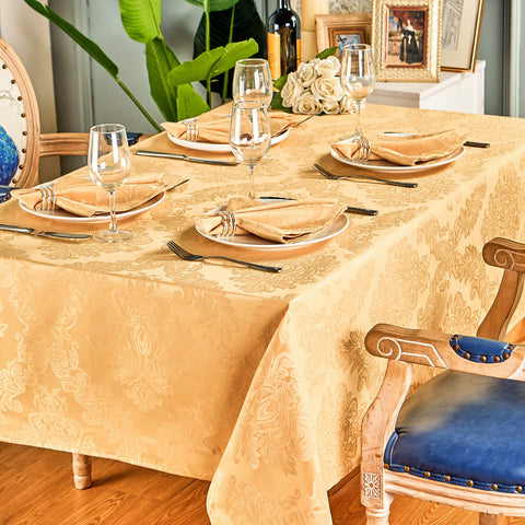 HomeJoy gold tablecloth in a festive dining setup with warm lighting.