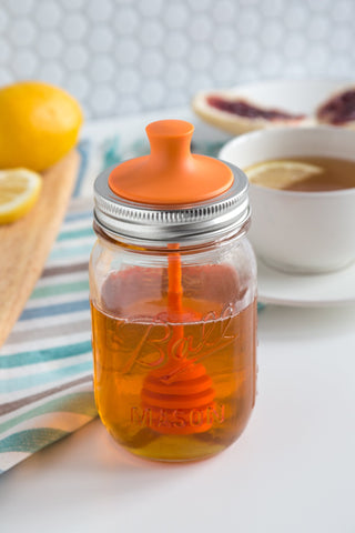 Orange Jarware lid-dipper on a regular-mouth jar for controlled honey drizzle.