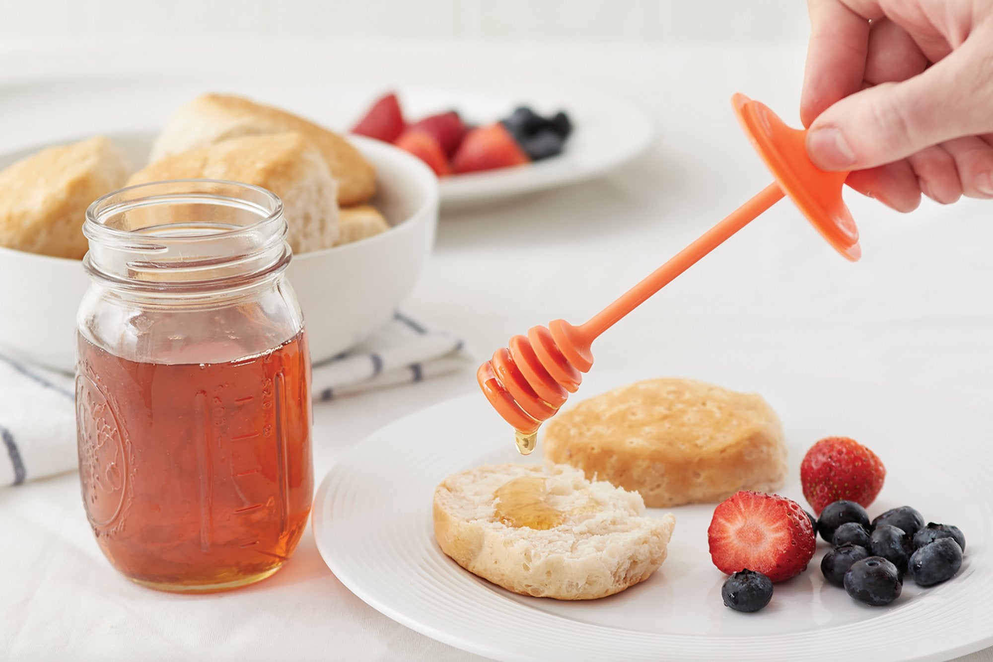 Orange Jarware honey dipper lid shown on a regular-mouth jar for tidy drizzle.