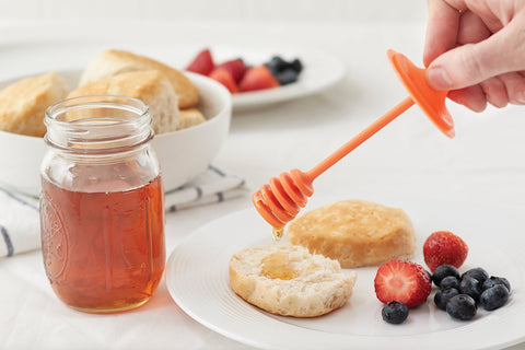 Orange Jarware honey dipper lid shown on a regular-mouth jar for tidy drizzle.