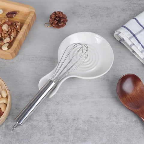 Wide base and swirl depression stabilize utensils during cooking.