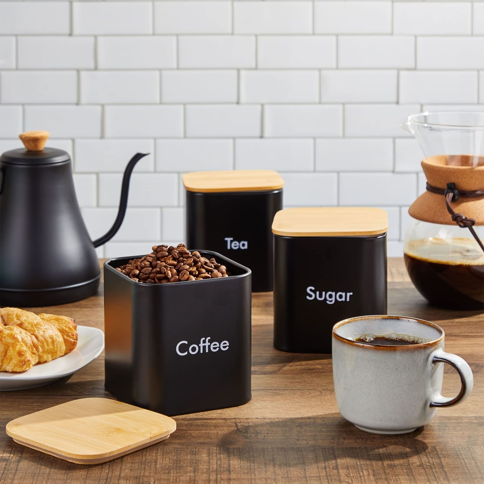 Juvale black iron tea canister keeps tea leaves fresh with airtight lid.
