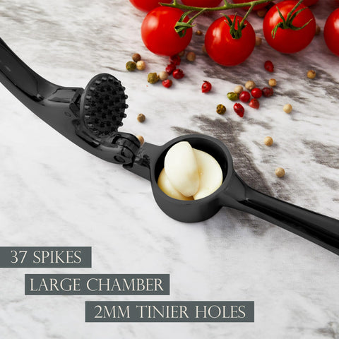 KITESSENSU garlic-press-holding-clove shows ergonomic grip for effortless mincing.